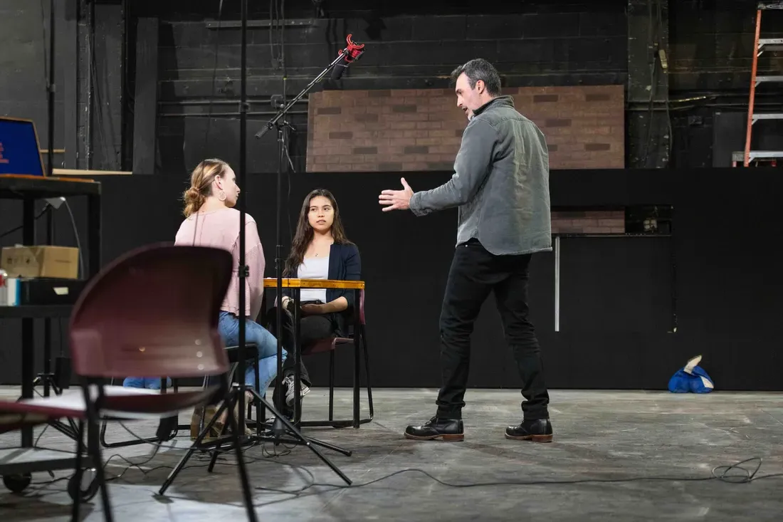 Alumni Reid Scott standing on a stage with students.